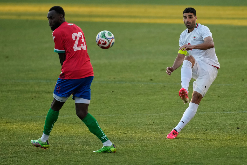 Iran's Mehdi Taremi, right, shoots the ball next to Gambia's Mouhamadou Drammeh during a friendly soccer match between Iran and Gambia, in Antalya, southern Turkey, Friday, May 29, 2026. (AP Photo/Khalil Hamra)