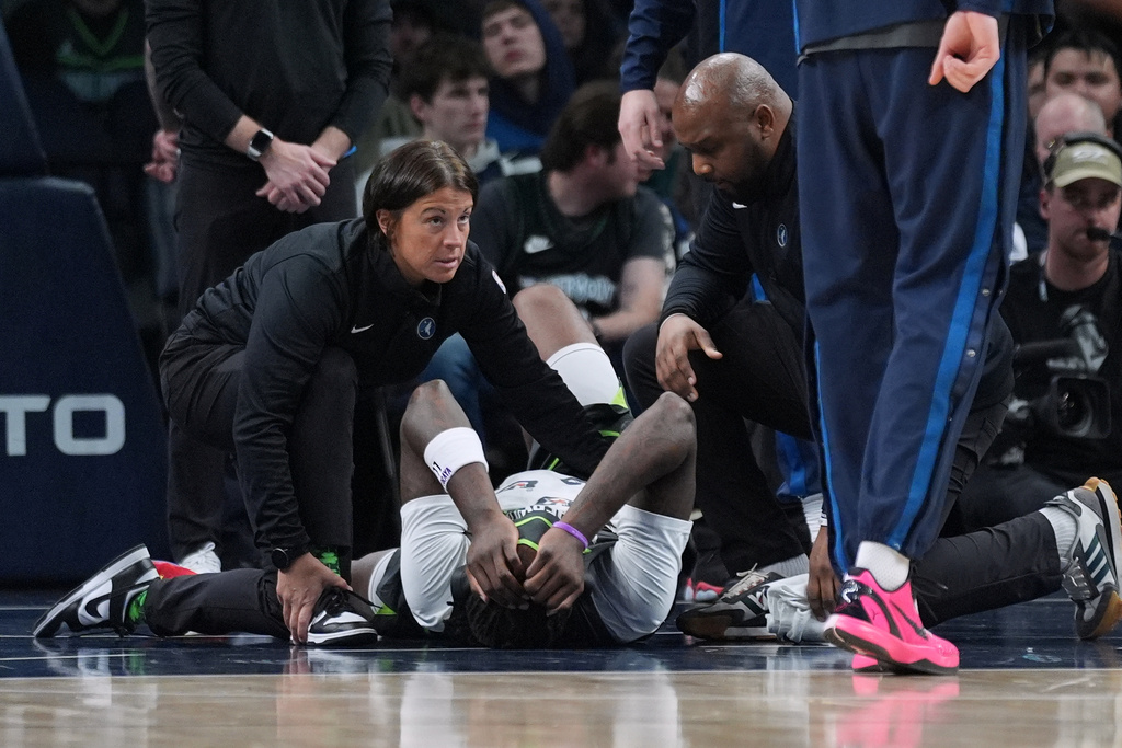 Minnesota Timberwolves center Naz Reid (11) lays on the ground after sustaining an injury during the first half of an NBA basketball game, against the Phoenix Suns Tuesday, March 17, 2026, in Minneapolis. (AP Photo/Abbie Parr)