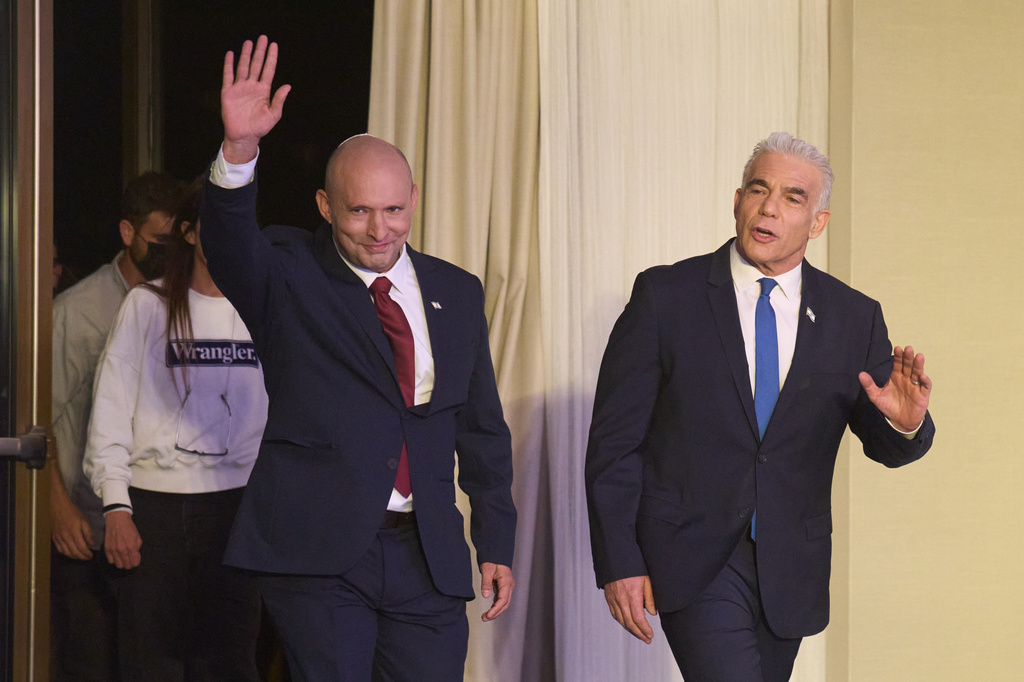 Former Israeli prime ministers Naftali Bennett, left, and Yair Lapid arrive to a joint press conference announcing that their parties will run together in the upcoming elections, in Herzliya, Israel, Sunday, April 26, 2026. (AP Photo/Ariel Schalit)