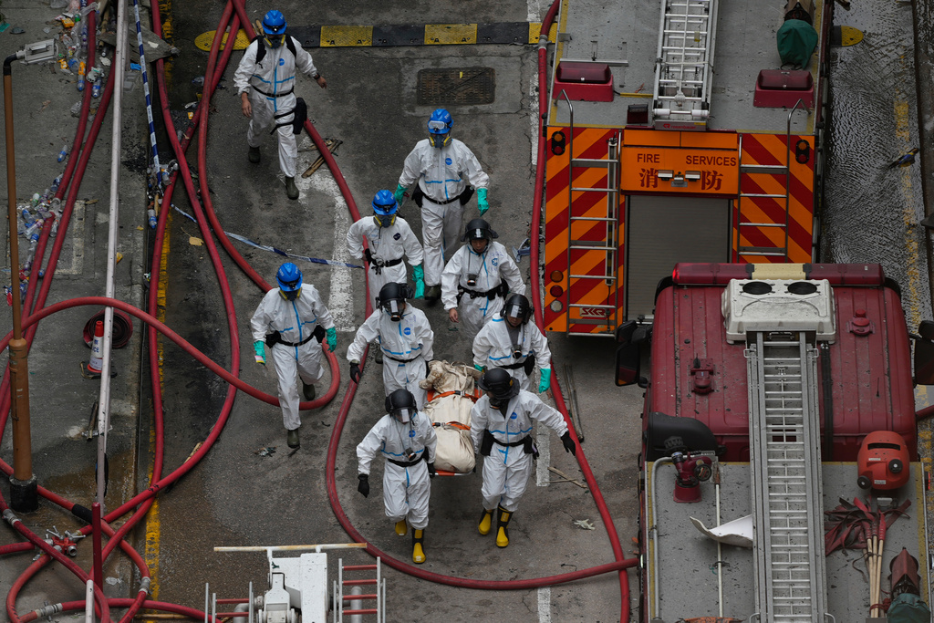 Emergency crew move what appears to be a body bag on a stretcher from the site of a deadly Wednesday fire at Wang Fuk Court, a residential estate in the Tai Po district of Hong Kong's New Territories on Sunday, Nov. 30, 2025. (AP Photo/Ng Han Guan)