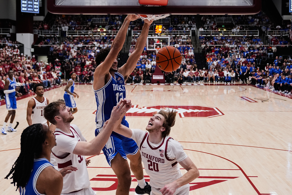 Duke forward Cameron Boozer (12) dunks next to Stanford forward Cameron Grant (20) during the first half of an NCAA college basketball game against Stanford, Saturday, Jan. 17, 2026, in Stanford, Calif. (AP Photo/Godofredo A. Vásquez)