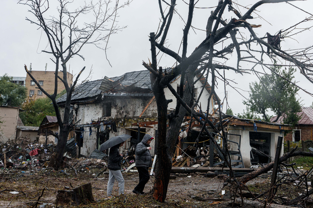 People walk in front of a house that was heavily damaged in a Russian strike on a residential neighbourhood in Kyiv, Ukraine, Thursday, Sept. 24, 2026. (AP Photo/Evgeniy Maloletka)