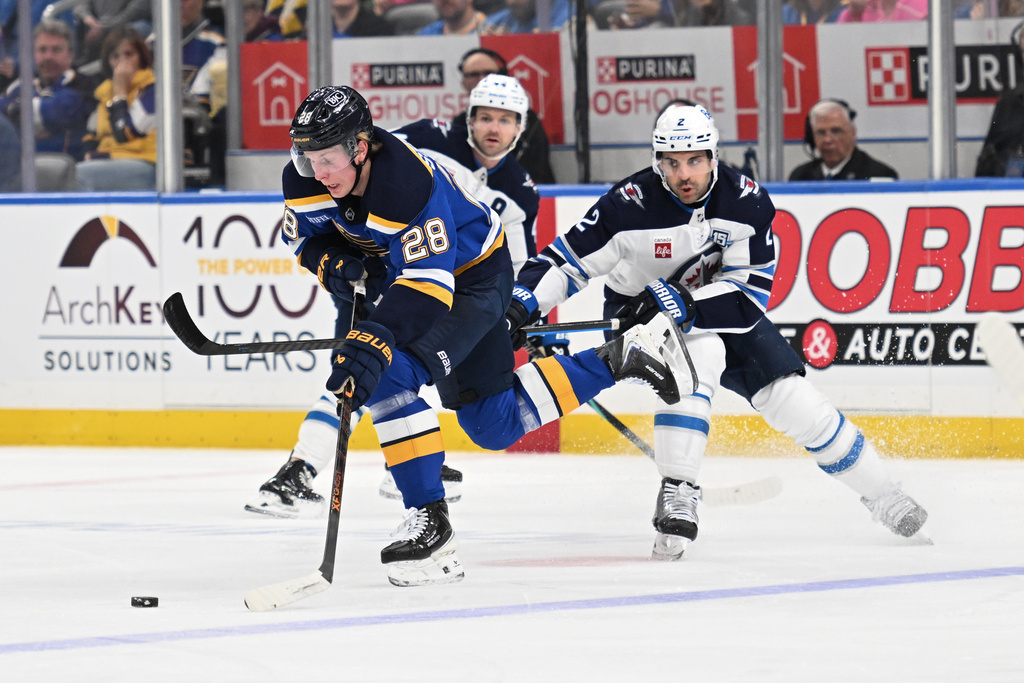 Winnipeg Jets defenseman Dylan Demelo (2), right, battles St. Louis Blues center Otto Stenberg (28) for the puck during the first period of an NHL hockey game on Wednesday, Dec. 17, 2025, in St. Louis. (AP Photo/Joe Puetz)