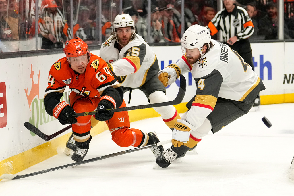 Anaheim Ducks center Mikael Granlund, left passes the puck while under pressure from Vegas Golden Knights defenseman Rasmus Andersson during the first period in Game 3 of a second-round NHL hockey Stanley Cup playoff series Friday, May 8, 2026, in Anaheim, Calif. (AP Photo/Mark J. Terrill)