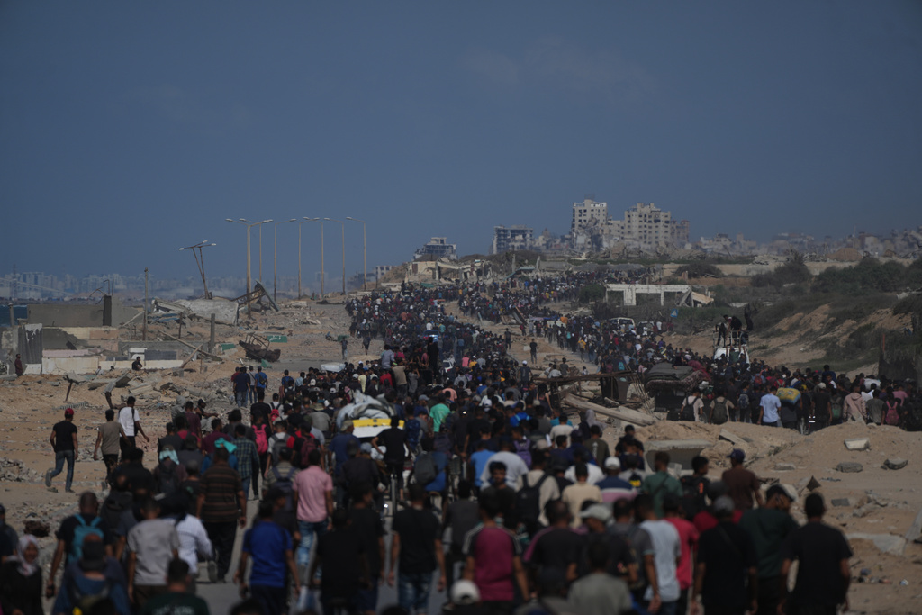 Displaced Palestinians walk with their belongings along the coastal road near Wadi Gaza in the central Gaza Strip, moving toward Gaza City, Friday, Oct. 10, 2025, after Israel and Hamas have agreed to a pause in their war and the release of the remaining hostages. (AP Photo/Abdel Kareem Hana)
