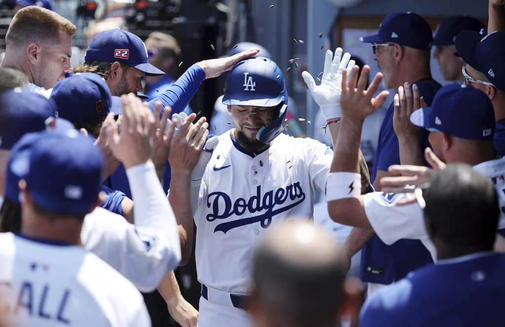 Los Angeles Dodgers outfielder Andy Pages is congratulated in the dugout after hitting a one-run home run against San Diego Padres pitcher Yu Darvish during the first inning of a baseball game, Sunday, Aug. 17, 2025, in Los Angeles. (AP Photo/Kevork Djansezian)