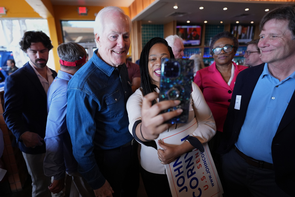 Sen. John Cornyn, R-Texas, left, poses for photos and visits with supporters during a campaign stop in Austin, Texas, Tuesday, Feb. 17, 2026. (AP Photo/Eric Gay)