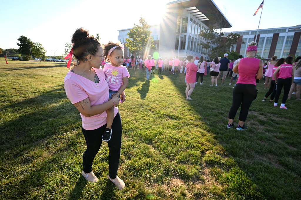 Mandie Reibold carries Michelle Martinez, 1, both of York, Pa., during a demonstration in support of Lindsay Clancy, who is on trial in connection with the deaths of her three children, outside Plymouth Superior Court on Thursday, Aug. 20, 2026, in Plymouth, Mass. (AP Photo/Josh Reynolds )