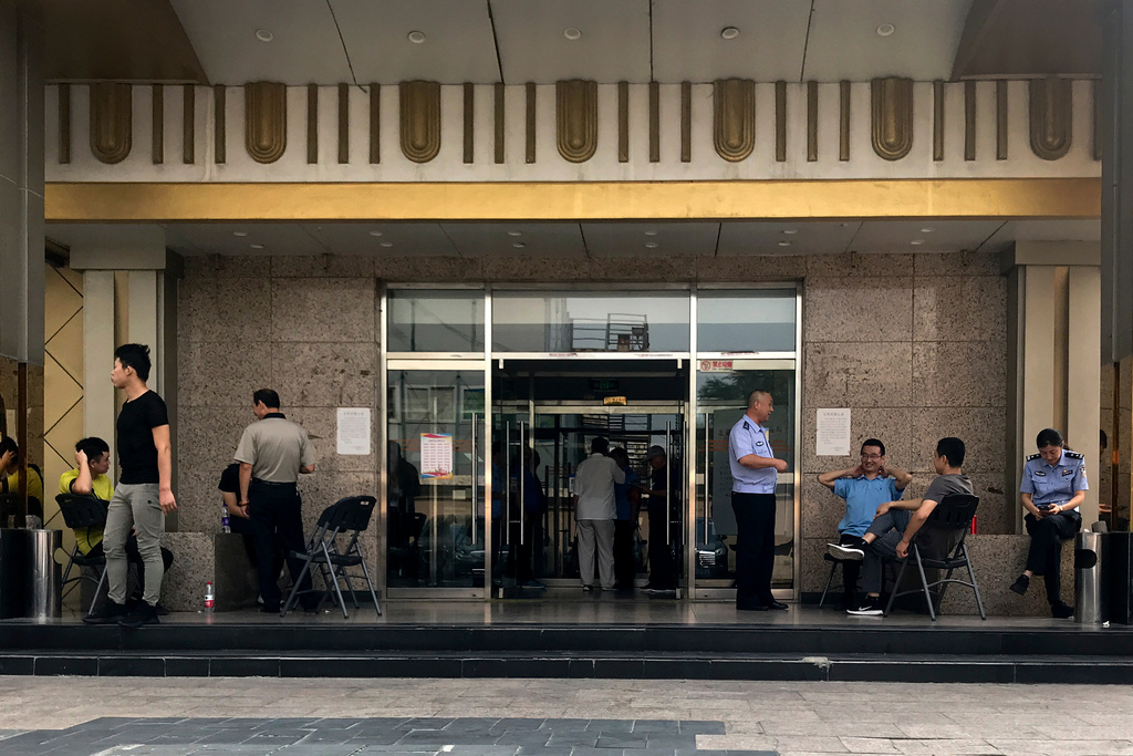 FILE -Police officers guard at the main entrance door to a building where Zion church is located after the church was shutdown by authorities in Beijing, Sept. 11, 2018. (AP Photo/Andy Wong, File)