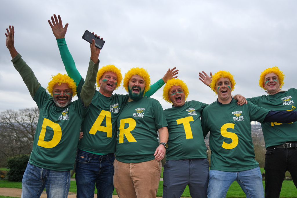 Darts fans arrive to watch the World Darts Championships, at Alexandra Palace in London, Monday, Dec. 15, 2025. (AP Photo/Kin Cheung)