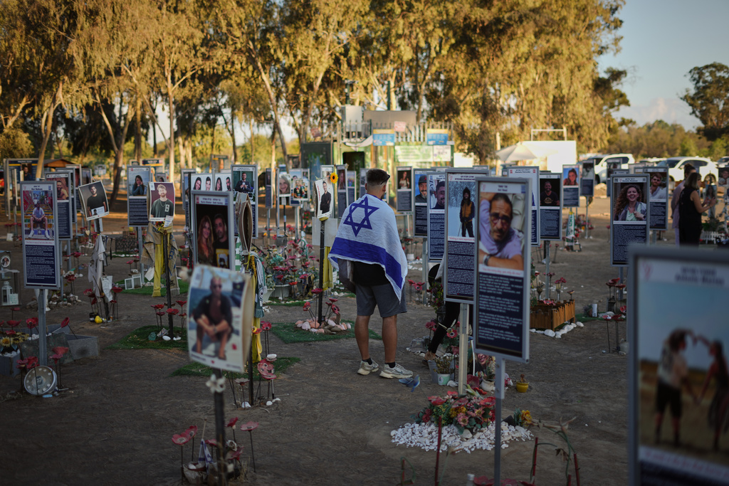 People visit the site of the Nova music festival, where hundreds of revelers were killed and abducted by Hamas and taken into Gaza, as Israel marks the second year anniversary of the attack, near Kibbutz Reim, southern Israel, Tuesday, Oct. 7, 2025. (AP Photo/Ariel Schalit)