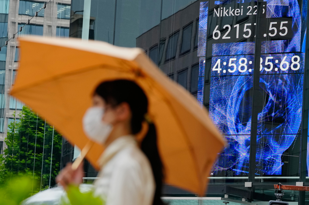 A person walks in front of an electronic stock board showing Japan's Nikkei index at a securities firm Tuesday, July 28, 2026, in Tokyo. (AP Photo/Eugene Hoshiko)