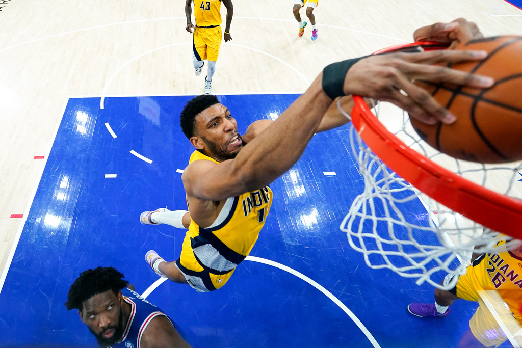 Indiana Pacers' Tony Bradley, center, dunks as Philadelphia 76ers' Joel Embiid, left, watches during the first half of an NBA basketball game, Monday, Jan. 19, 2026, in Philadelphia. (AP Photo/Chris Szagola)