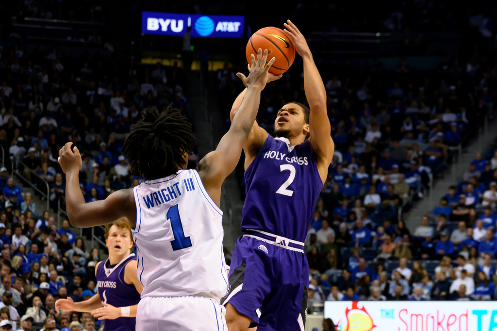 Holy Cross guard Deandre Williams (2) shoots the ball over BYU guard Robert Wright III (1) during the second half of an NCAA college basketball game, Saturday, Nov. 8, 2025, in Provo, Utah. (AP Photo/Tyler Tate)