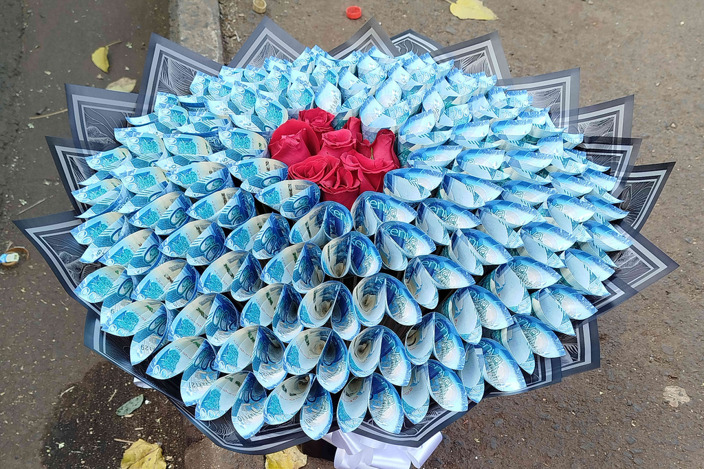 A flower bouquet that incorporates real money sits for sale on the sidewalk in Nairobi, Kenya, Wednesday, Nov. 26, 2025. (AP Photo/Duke Monari)