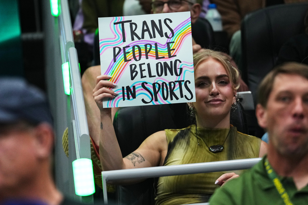 A person holds a "trans people belong in sports" sig during the first half of a WNBA basketball game between the Seattle Storm and the Indiana Fever, Tuesday, July 28, 2026, in Seattle. (AP Photo/Lindsey Wasson)