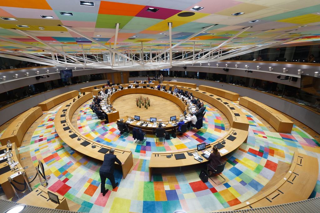 Hungary's Prime Minister Viktor Orban, left, watches from outside the main table as Ukraine's President Volodymyr Zelenskyy speaks to EU leaders via video link during a round table meeting at the EU summit in Brussels, Thursday, March 19, 2026. (AP Photo/Geert Vanden Wijngaert, Pool)