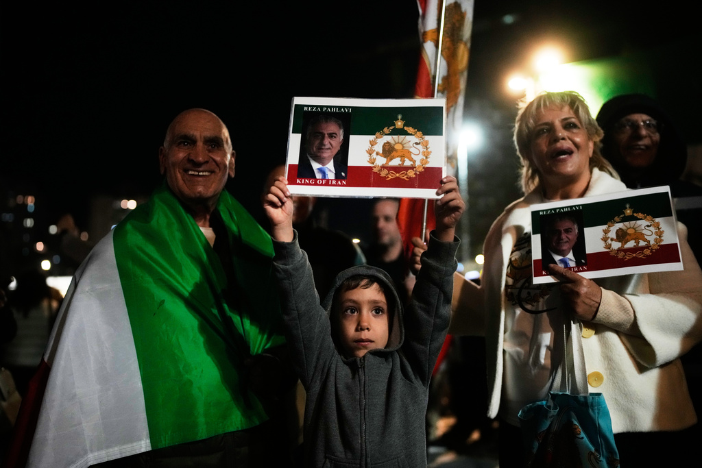 Demonstrators wave pre-revolution Iran flag and posters of Iran's exiled crown prince Reza Pahlavi during a rally in support of Iran's anti-government protests, in Holon, Israel Wednesday, Jan. 14, 2026. (AP Photo/Ohad Zwigenberg)