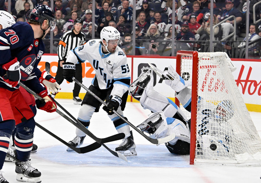 Utah Mammoth goaltender Vitek Vanecek, right, falls into his net after a shot by the Winnipeg Jets as Mammoth's Michael Carcone (53) defends during the second period of an NHL hockey game in Winnipeg, Manitoba, Sunday, Oct. 26, 2025. (Fred Greenslade/The Canadian Press via AP) Utah Mammoth goaltender Vitek Vanecek, right, falls into his net after a shot by the Winnipeg Jets as Mammoth's Michael Carcone (53) defends during the second period of an NHL hockey game in Winnipeg, Manitoba, Sunday, Oct. 26, 2025. (Fred Greenslade/The Canadian Press via AP)