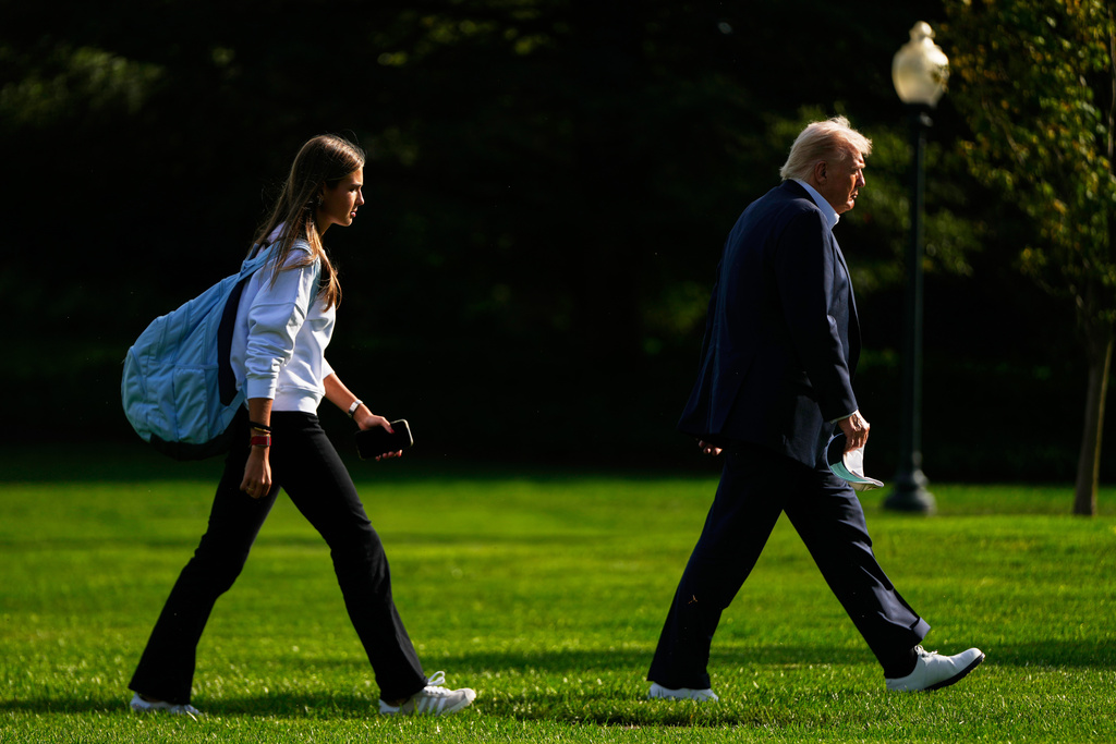 FILE - President Donald Trump, right, arrives with his granddaughter Kai Trump at the White House, Friday, Sept. 26, 2025, in Washington. (AP Photo/Julia Demaree Nikhinson, file)