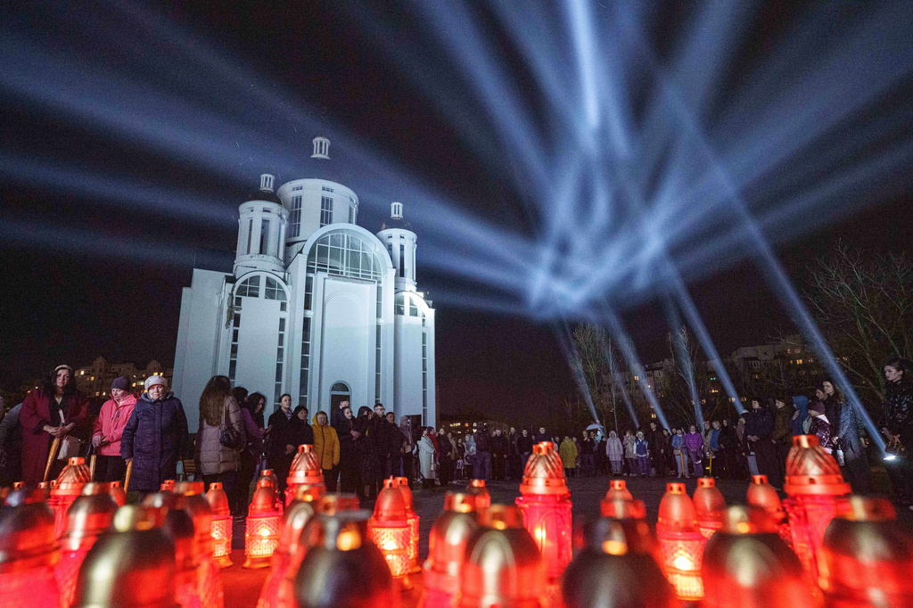 People attend a ceremony at a memorial for killed civilians to mark the fourth anniversary of the liberation of Bucha, Ukraine, on Monday, March 30, 2026. (AP Photo/Evgeniy Maloletka)