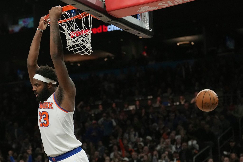 New York Knicks center Mitchell Robinson (23) dunks against the Phoenix Suns during the first half of an NBA basketball game, Friday, Jan. 9, 2026, in Phoenix. (AP Photo/Ross D. Franklin)