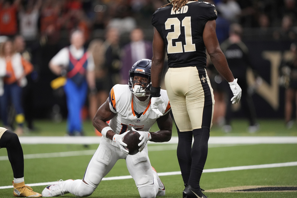 Denver Broncos wide receiver Courtland Sutton, left, reacts after catching a pass for a touchdown as New Orleans Saints safety Justin Reid looks on in the first half of an NFL preseason football game Saturday, Aug. 23, 2025, in New Orleans. (AP Photo/Gerlad Herbert)