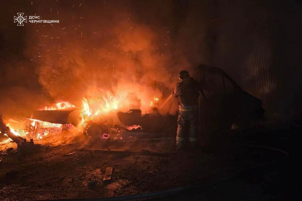 In this photo provided by the Ukrainian Emergency Service on Tuesday, Dec. 23, 2025, a rescue worker puts out a fire of a car destroyed a Russian strike in Chernihiv region, Ukraine. (Ukrainian Emergency Service via AP)