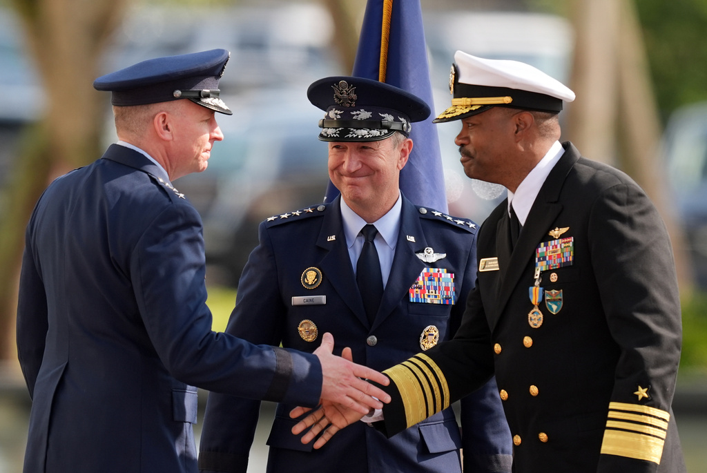 Gen. Dan Caine, center, chairman of the Joint Chiefs of Staff, looks on as Navy Adm. Alvin Holsey, right, shakes hands with Air Force Lt. Gen. Evan Pettus during a Holsey's relinquishment of command and retirement ceremony, at U.S. Southern Command, Friday, Dec. 12, 2025, in Doral, Fla. (AP Photo/Rebecca Blackwell)