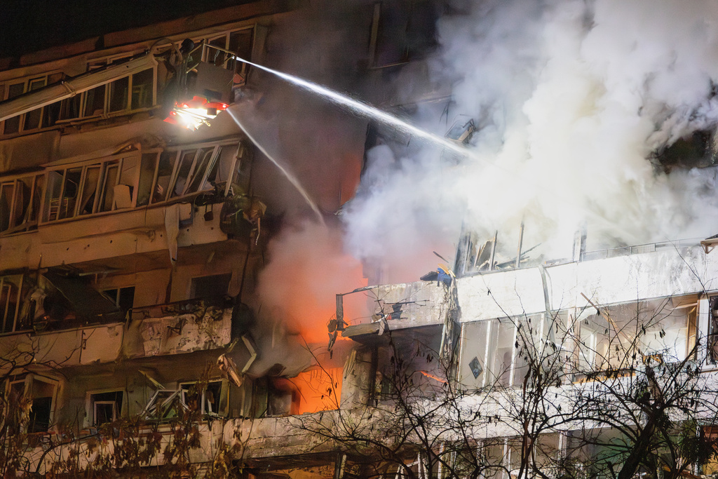 Firefighters put out a blaze after a drone hit a multistory residential building during Russia's night drone attack in Kyiv, Ukraine, Tuesday, Nov. 25, 2025. (AP Photo/Efrem Lukatsky)