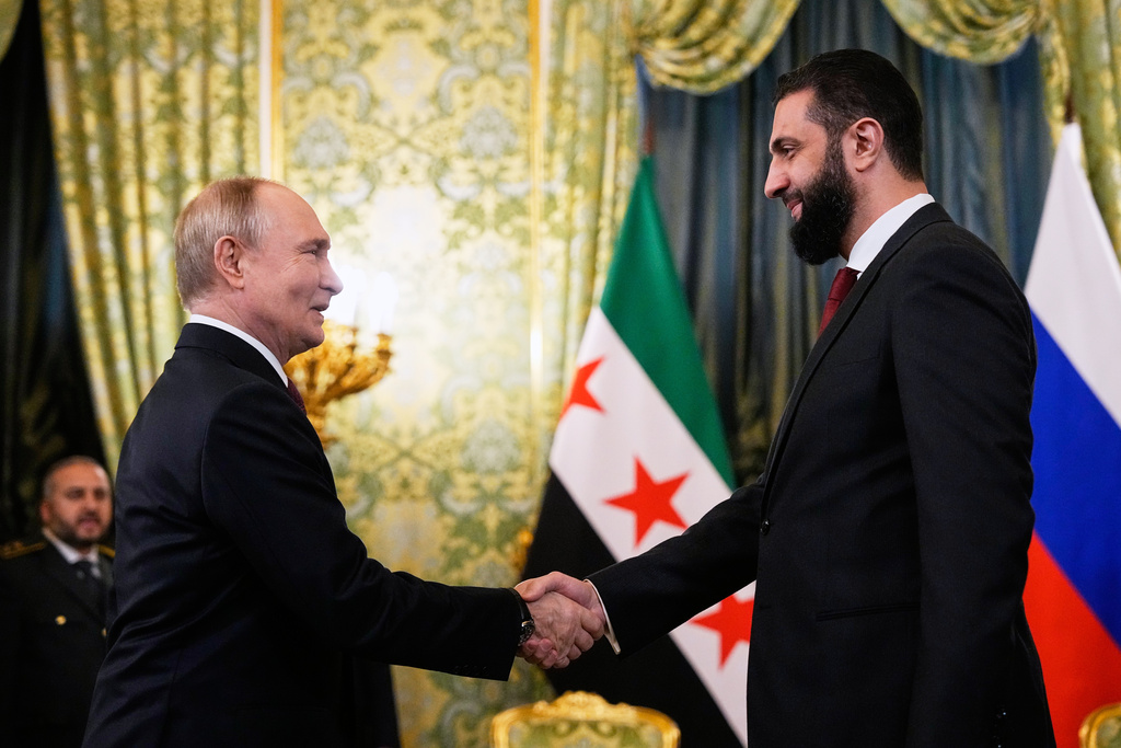 Russian President Vladimir Putin, left, and Syrian interim President Ahmad al-Sharaa shake hands during their meeting at the Grand Kremlin Palace in Moscow, Russia, Wednesday, Oct. 15, 2025. (AP Photo/Alexander Zemlianichenko, Pool)