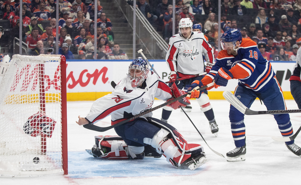 Washington Capitals goalie Charlie Lindgren (79) is scored on as Edmonton Oilers' Zach Hyman (18) knocks his glove off during the second period of an NHL game, in Edmonton on Saturday, Jan. 24, 2026. (Jason Franson/The Canadian Press via AP)