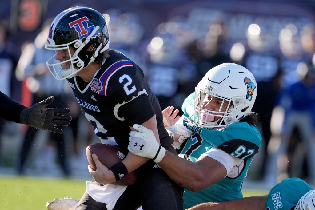 Louisiana Tech quarterback Trey Kukuk (2) is sacked by Coastal Carolina defensive lineman Jordan Mack (97) during the second half of the Independence Bowl NCAA college football game, Tuesday, Dec. 30, 2025, in Shreveport, La. (AP Photo/Rogelio V. Solis)