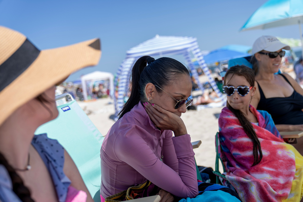 Ruth Wilson begins to feel a migraine and fatigue, as too much sunshine is one of her lupus symptom triggers, while at the beach with family, Saturday, Aug. 16, 2025, in South Yarmouth, Mass. (AP Photo/David Goldman)