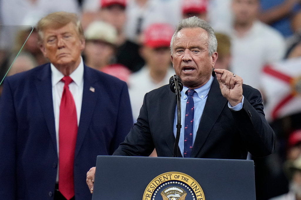 Health and Human Services Secretary Robert F. Kennedy Jr. speaks as President Donald Trump listens during a campaign rally, Friday, Oct. 23, 2026, at Alico Arena on the campus of Florida Gulf Coast University in Fort Myers, Fla. (AP Photo/Chris O'Meara)