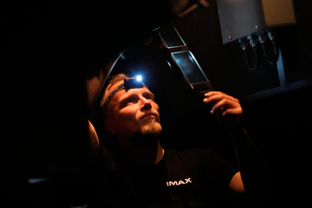 Tomas Vysinsky prepares the 70 mm IMAX copy of Christopher Nolan's "The Odyssey" for screening in Prague, Czech Republic, Monday, July 27, 2026. (AP Photo/Petr David Josek)