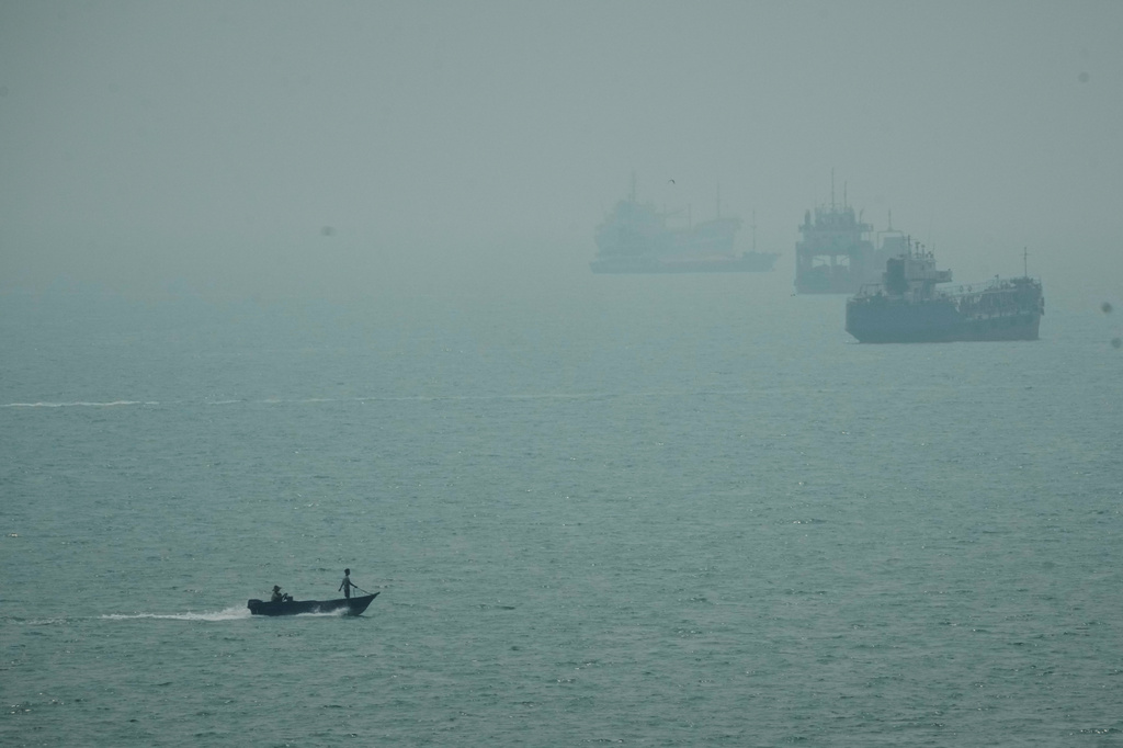 A motorboat travels past commercial vessels anchored amid haze in the Strait of Hormuz off Bandar Abbas, Iran, Monday, Sept. 7, 2026. (AP Photo/Vahid Salemi)