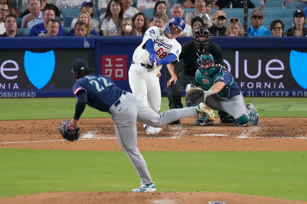 Los Angeles Dodgers' Dalton Rushing, second from left, hits a three-run home run as Seattle Mariners starting pitcher Bryan Woo, left, and catcher Cal Raleigh watch during the fourh inning of a baseball game Thursday, July 30, 2026, in Los Angeles. (AP Photo/Mark J. Terrill)