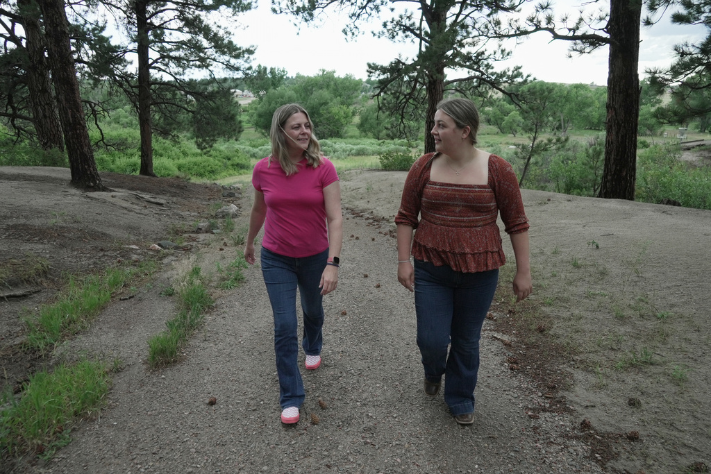 Anne Schultz and her daughter, Charlotte Touzalin, go on a walk Friday, July 10, 2026 in Elizabeth, Colo. (AP Photo/Brittany Peterson)