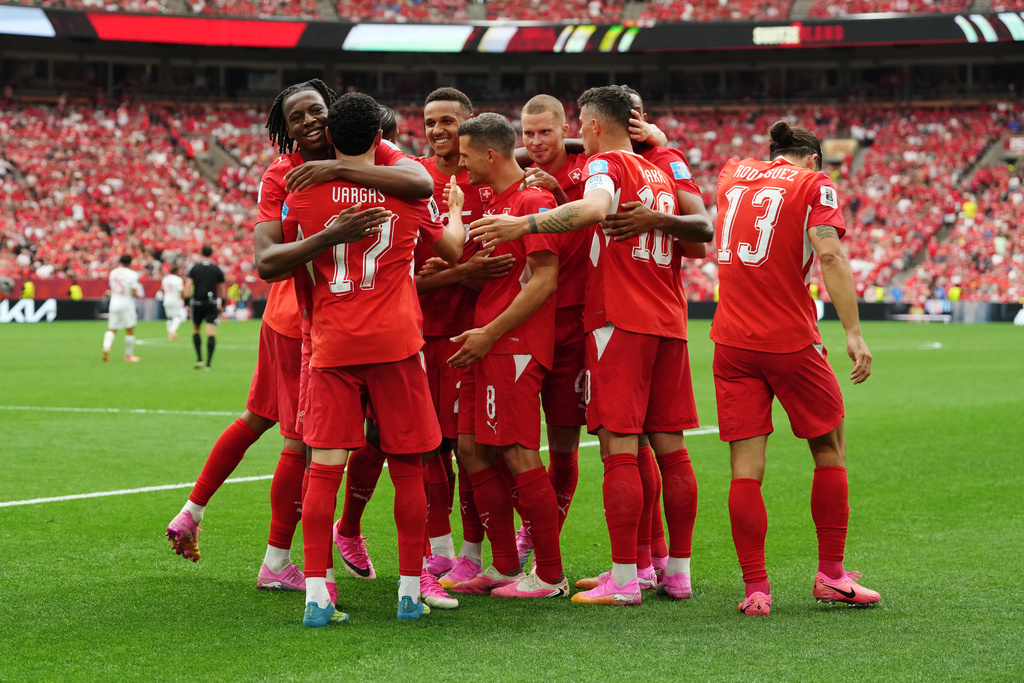 Switzerland's Ruben Vargas (17) is mobbed by teammates after scoring their first goal during the World Cup Group B soccer match between Switzerland and Canada in Vancouver, British Columbia, Wednesday, June 24, 2026. (Ethan Cairns/The Canadian Press via AP)