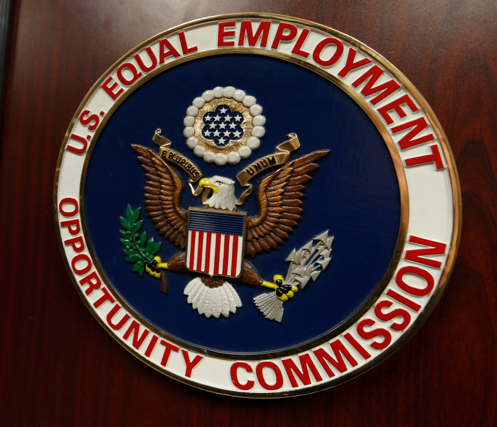 FILE - The emblem of the U.S. Equal Employment Opportunity Commission (EEOC) is displayed on a podium in Denver on Feb. 16, 2016. (AP Photo/David Zalubowski, File)