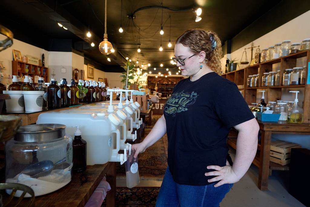 Aaralyn Holt refills bottles at Lufka Refillable Zero Waste store Wednesday, Feb. 18, 2026, in Tampa, Fla. (AP Photo/Chris O'Meara)