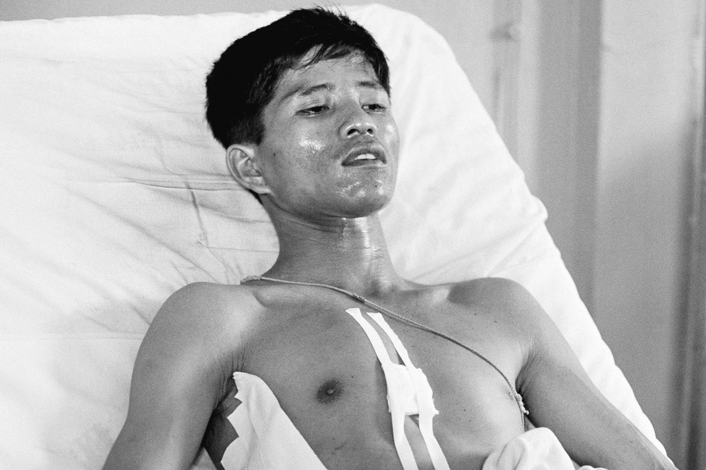 FILE - Dang Van Phuoc, 22, a Vietnamese photographer working with the Associated Press, lies in a bed at the Vietnamese Military Hospital at Can Tho, Vietnam, 80 miles south of Saigon, March 19, 1969, after he was seriously injured during intense combat. (AP Photo/Al Chang, File)