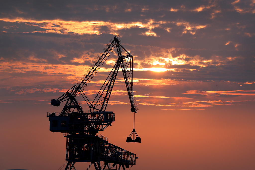 FILE - A crane is silhouetted as it transfers coal during a sunset at a port in Osaka, western Japan on Aug. 18, 2019. (AP Photo/Andy Wong, File)
