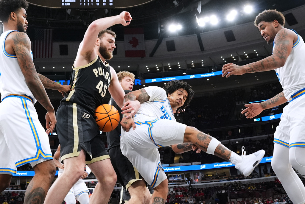 Purdue center Oscar Cluff (45) battles for a rebound with UCLA guard Skyy Clark during the first half of an NCAA college basketball game in the semifinals of the Big 10 Conference tournament, Saturday, March 14, 2026, in Chicago. (AP Photo/Nam Y. Huh)