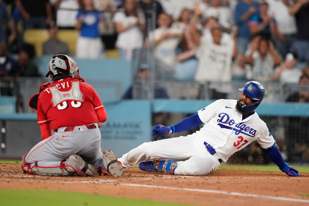 Los Angeles Dodgers' Teoscar Hernández, right, is tagged out by Cincinnati Reds catcher Jose Trevino as he tries to score on an inside-the-park home run during the third inning of a baseball game Tuesday, Sept. 8, 2026, in Los Angeles. (AP Photo/Mark J. Terrill)