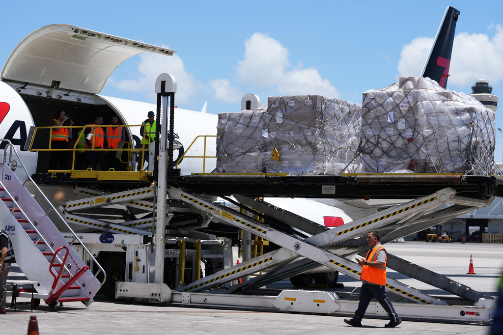People load pallets containing food and hygiene kits for a humanitarian assistance flight to Cuba organized by the Trump administration as the U.S. continues to put pressure on the island's government, Tuesday, July 21, 2026, in Miami. (AP Photo/Lynne Sladky)