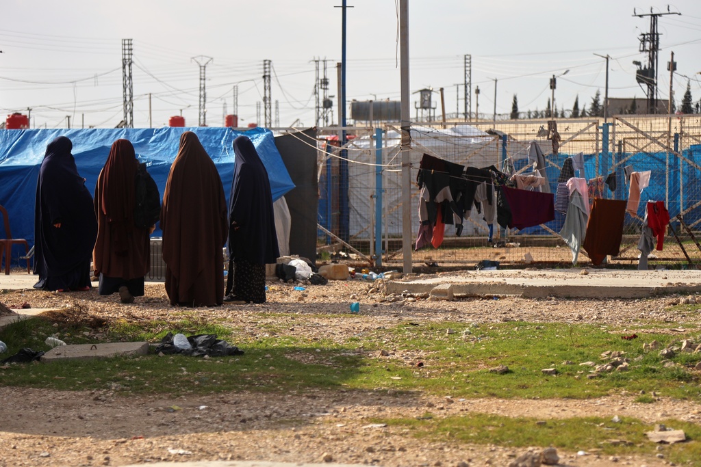 Unidentified women stand in a section of the camp housing Australian family members of suspected Islamic State militants who were returned to due to unspecified procedural issues following an attempted repatriation by Syrian authorities, in the Roj Camp in eastern Syria, Wednesday, Feb. 18, 2026. (AP Photo/Baderkhan Ahmad)