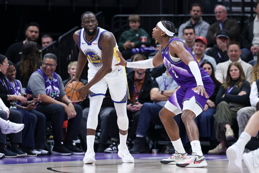 Golden State Warriors forward Draymond Green, left, looks for a play as Utah Jazz forward Blake Hinson (2) defends during the first half of an NBA basketball game, Monday, March 9, 2026, in Salt Lake City. (AP Photo/Rob Gray)