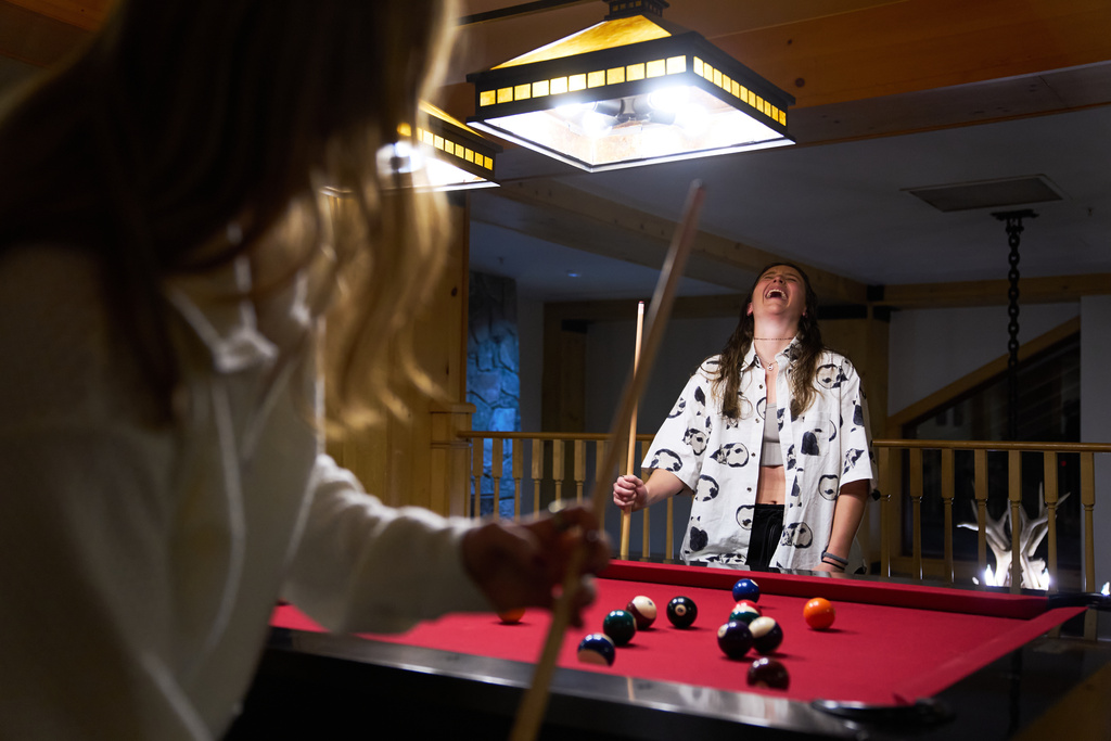 Skier Lauren Macuga, 23, of Park City, Utah, laughs while playing pool with members of the U.S. Women's Ski Team after practice at Copper Mountain, Colo., Nov. 19, 2025. (AP Photo/Jacquelyn Martin)